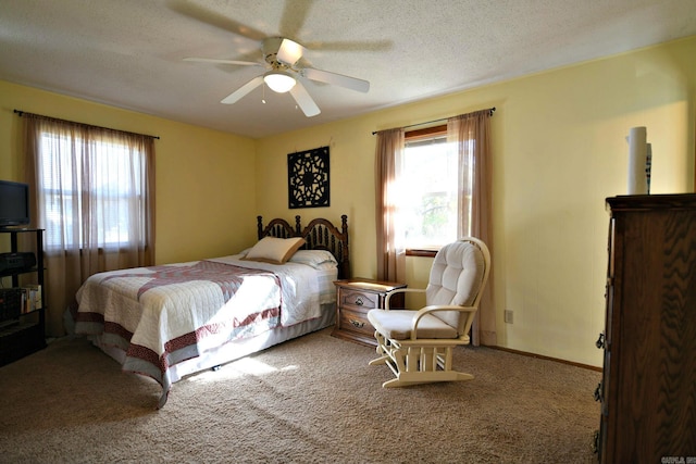 carpeted bedroom featuring ceiling fan and a textured ceiling