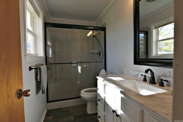 bathroom featuring walk in shower, vanity, crown molding, wood-type flooring, and toilet