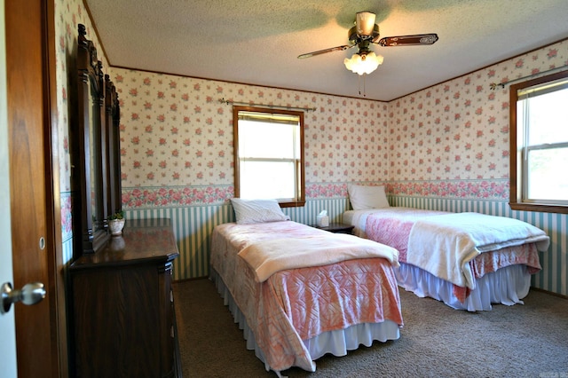 carpeted bedroom with ceiling fan and a textured ceiling