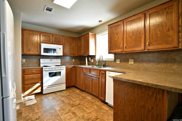 kitchen featuring a textured ceiling, decorative backsplash, white appliances, and sink