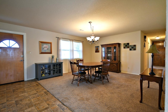 carpeted dining room featuring a textured ceiling and an inviting chandelier