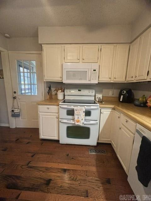 kitchen featuring a textured ceiling, white cabinetry, dark hardwood / wood-style flooring, and white appliances