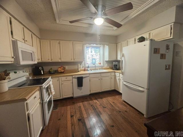 kitchen featuring white appliances, dark wood-type flooring, sink, a textured ceiling, and white cabinetry