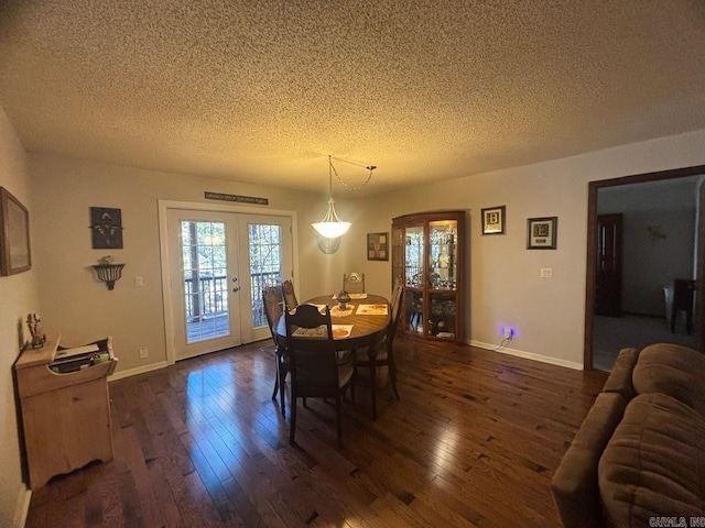 dining space with a textured ceiling, french doors, and dark hardwood / wood-style floors