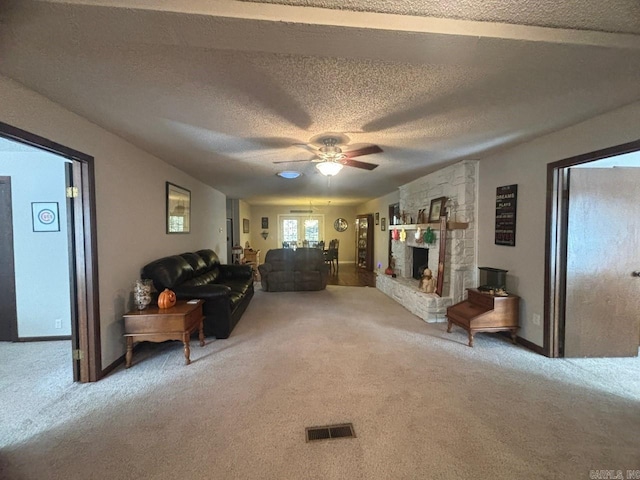 living room featuring carpet flooring, a textured ceiling, and ceiling fan