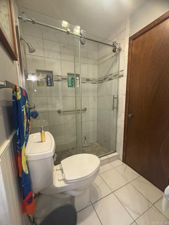 bathroom featuring toilet and an enclosed shower