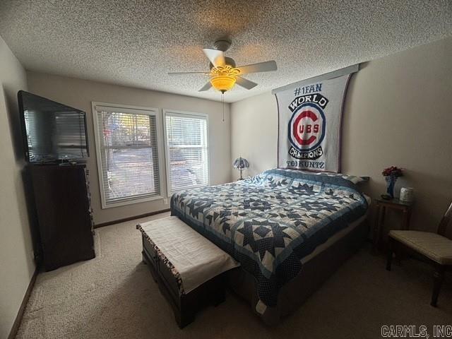 bedroom featuring ceiling fan, carpet floors, and a textured ceiling