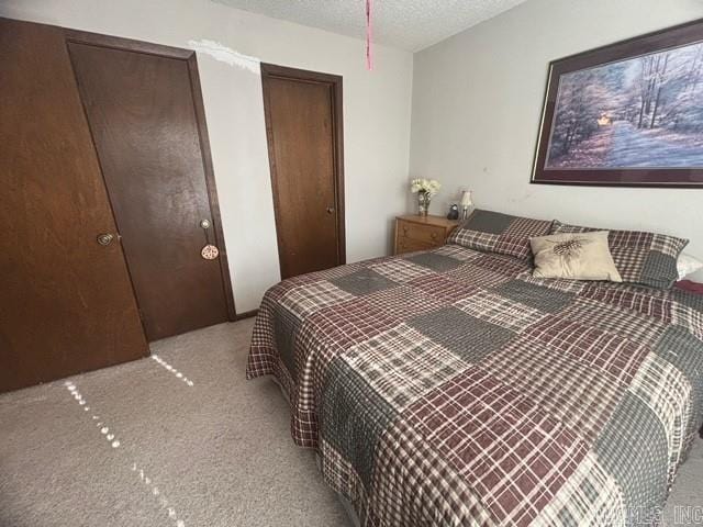 bedroom featuring light colored carpet and a textured ceiling