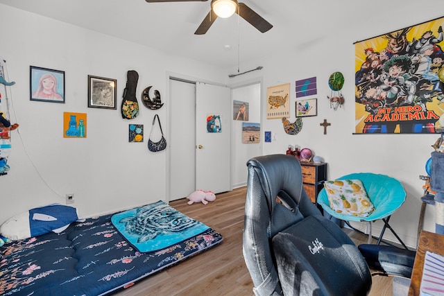 bedroom featuring hardwood / wood-style flooring, ceiling fan, and a closet