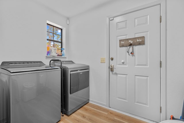 laundry room featuring washing machine and clothes dryer and light wood-type flooring