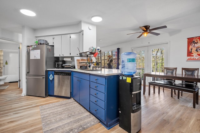 kitchen with blue cabinetry, white cabinetry, light wood-type flooring, and appliances with stainless steel finishes