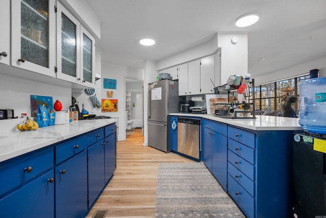 kitchen featuring white cabinets, blue cabinetry, stainless steel appliances, and light hardwood / wood-style flooring