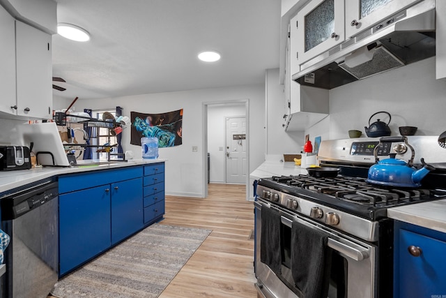 kitchen with blue cabinetry, white cabinets, light wood-type flooring, and appliances with stainless steel finishes