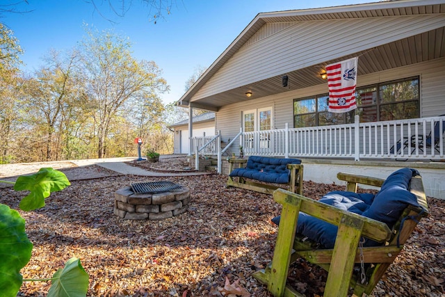 exterior space with a porch, a garage, and an outdoor fire pit