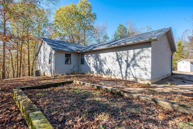 view of side of property with a storage unit and cooling unit