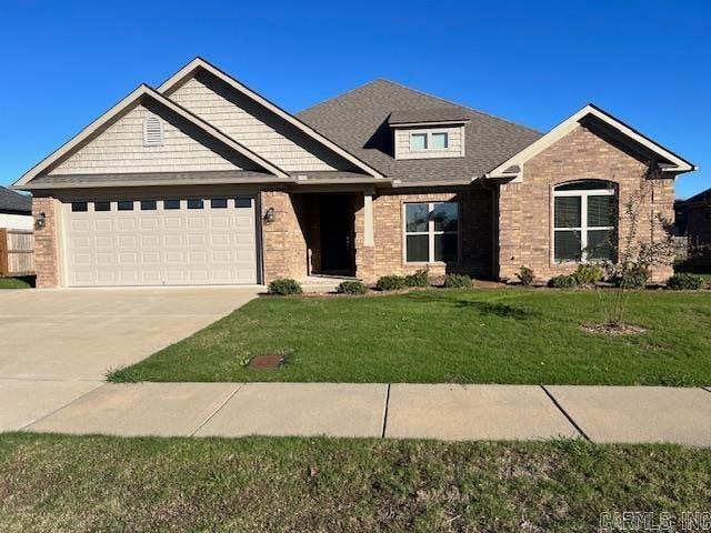 craftsman-style home featuring a front yard and a garage