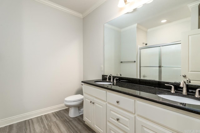 bathroom with vanity, a shower with door, crown molding, wood-type flooring, and toilet