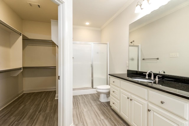 bathroom with ornamental molding, a shower with shower door, and hardwood / wood-style flooring