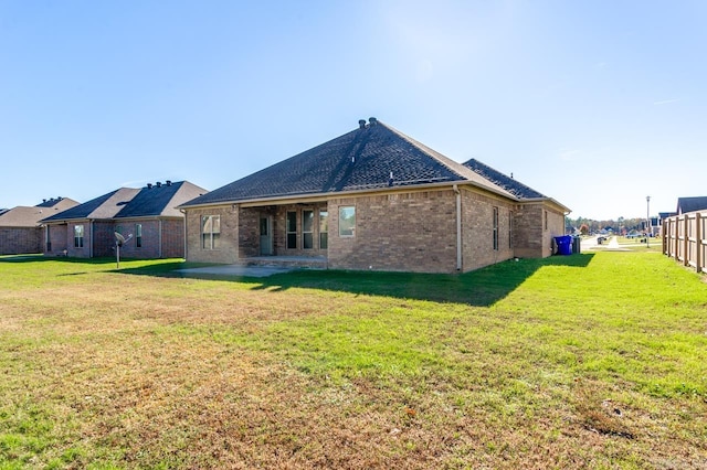 rear view of house featuring a patio and a lawn