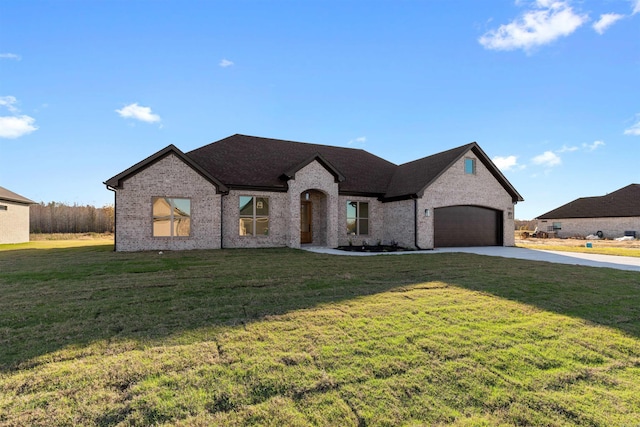 french country home featuring a front lawn and a garage