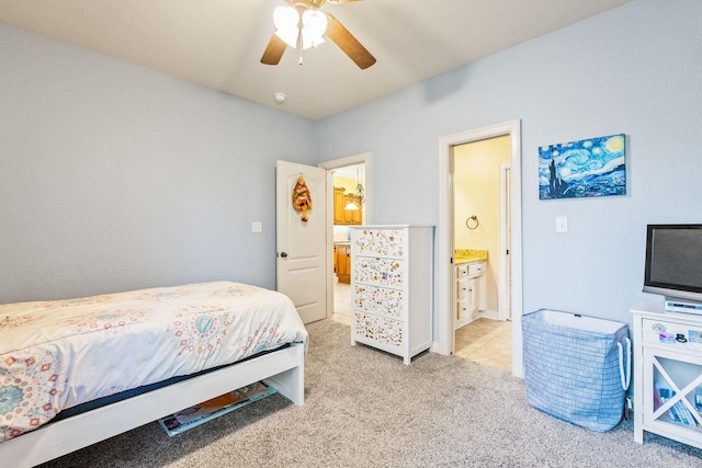 bedroom with connected bathroom, light colored carpet, and ceiling fan