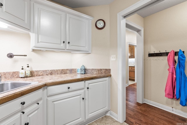 kitchen featuring wood-type flooring and white cabinetry