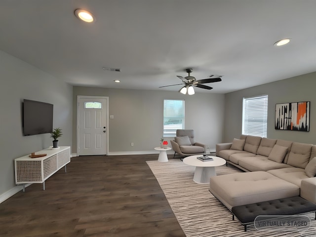 living room featuring ceiling fan and dark wood-type flooring