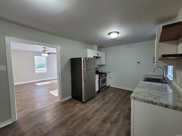 kitchen featuring sink, wooden walls, dark hardwood / wood-style floors, appliances with stainless steel finishes, and white cabinetry