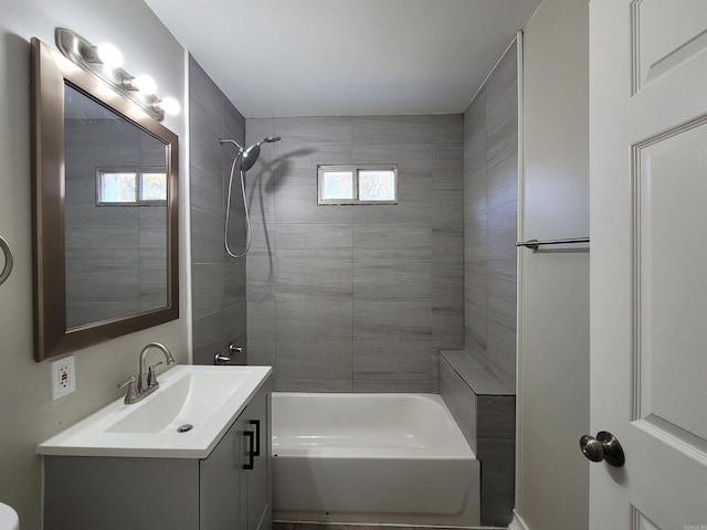 bathroom with vanity and tiled shower / bath