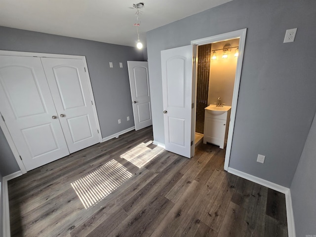 bedroom featuring sink, dark hardwood / wood-style flooring, a closet, and connected bathroom