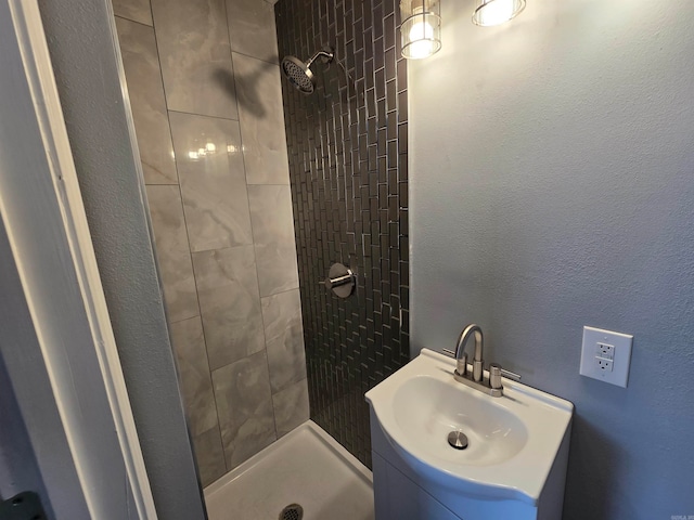 bathroom with a tile shower and sink