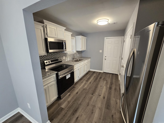 1903 W 24th Ave, Pine Bluff, AR 71603 - kitchen with appliances with stainless steel finishes, a sink, white cabinetry, baseboards, and decorative backsplash
