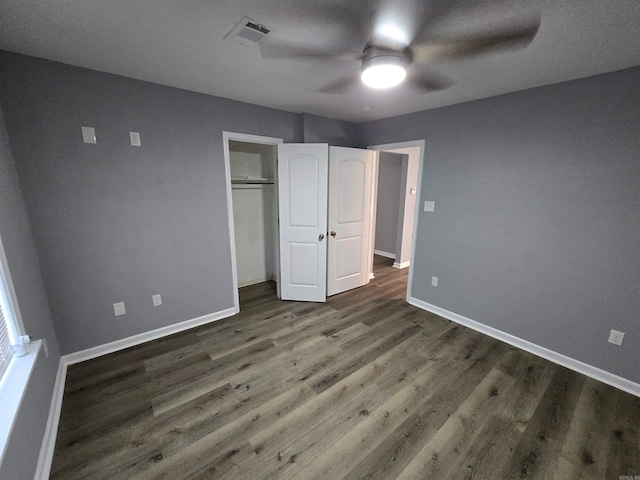 unfurnished bedroom featuring ceiling fan, dark hardwood / wood-style floors, a textured ceiling, and a closet