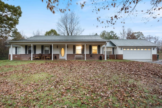 ranch-style home featuring covered porch and a garage