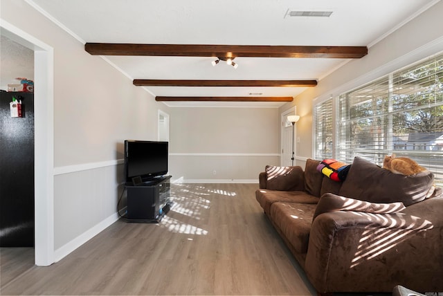 living room with hardwood / wood-style flooring, ornamental molding, and beamed ceiling