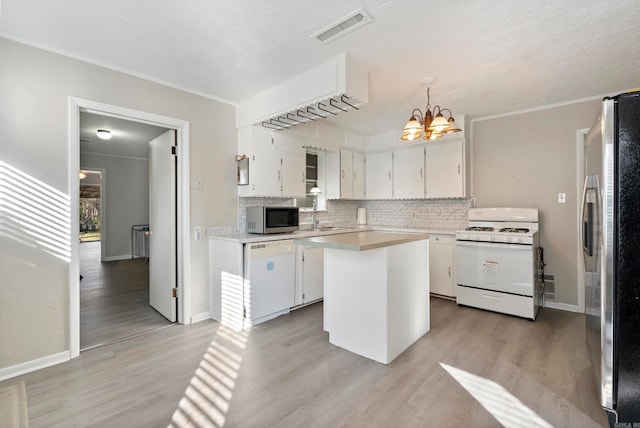 kitchen featuring white cabinetry, a center island, decorative light fixtures, appliances with stainless steel finishes, and light wood-type flooring