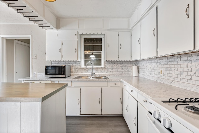 kitchen with white cabinetry, sink, dark hardwood / wood-style flooring, decorative backsplash, and white stove