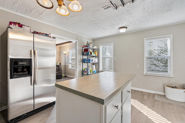 kitchen with white cabinetry, stainless steel fridge, plenty of natural light, and light hardwood / wood-style flooring