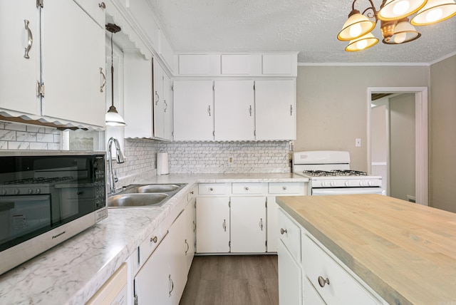 kitchen with white cabinets, decorative light fixtures, white range with gas stovetop, and dark wood-type flooring