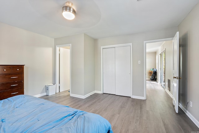 bedroom with ceiling fan, light wood-type flooring, and a closet