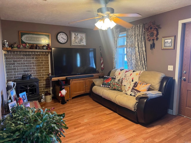 living room featuring a textured ceiling, light hardwood / wood-style floors, and ceiling fan