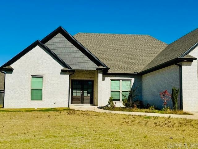 rear view of house with a lawn and french doors