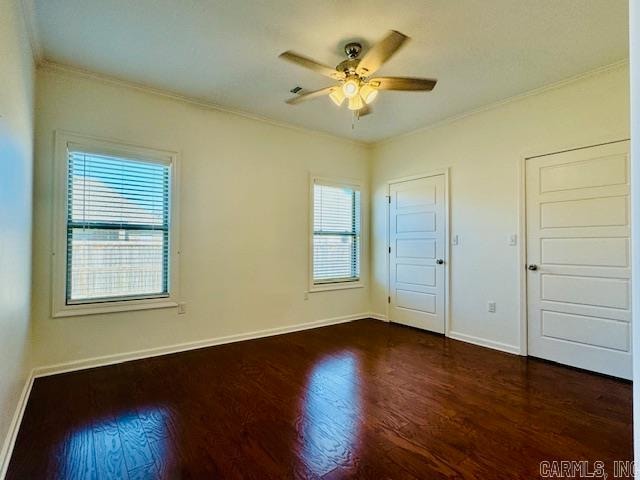 unfurnished bedroom featuring ceiling fan, dark hardwood / wood-style flooring, crown molding, and multiple windows