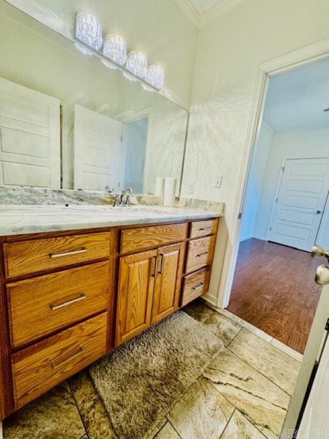 bathroom with crown molding, vanity, and wood-type flooring