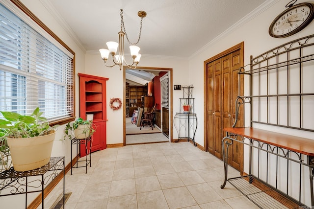 tiled foyer with ornamental molding, a textured ceiling, and an inviting chandelier