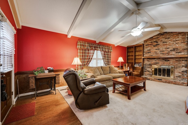 living room featuring a fireplace, wood-type flooring, vaulted ceiling with beams, and ceiling fan