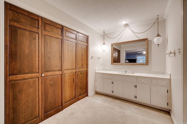 bathroom with vanity, crown molding, and a textured ceiling