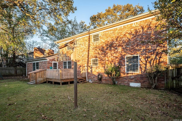 back of property with a lawn and a wooden deck