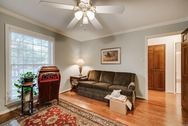 living room featuring a textured ceiling, hardwood / wood-style flooring, ceiling fan, and crown molding