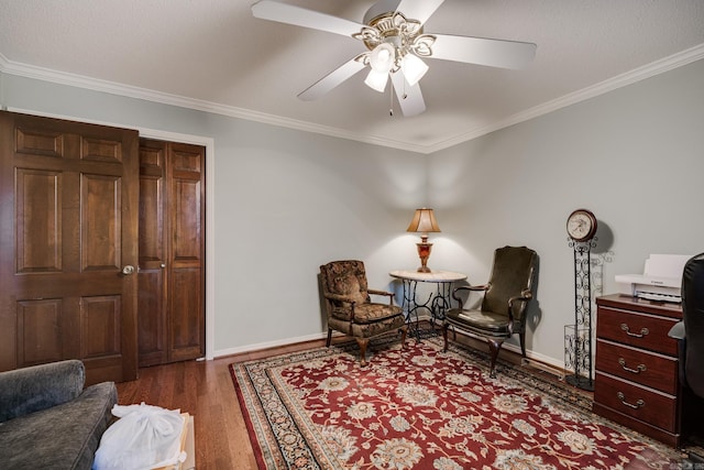 sitting room with crown molding, dark hardwood / wood-style flooring, and ceiling fan